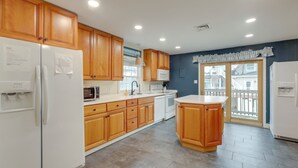 A modern kitchen with wooden cabinets, a refrigerator, a microwave, and a sink. - < 1/2 Mi to Boardwalk: Roomy Wildwood Retreat! (North Wildwood)