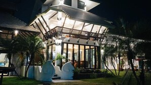 A two-story house with a balcony and a covered patio area. - Maison De Chiangrai (Chiang Rai)