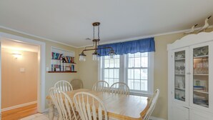 A dining area with a wooden table and chairs, a bookshelf, and a cabinet with glass doors. - < 1/2 Mi to Beach: Wildwood Getaway w/ Patio! (North Wildwood)