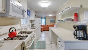 A compact kitchen with white cabinets, a gas stove, a microwave, and a coffee maker. - < 1/2 Mi to Beach: Wildwood Getaway w/ Patio! (North Wildwood)