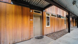 A building with wooden exterior walls, a concrete entrance, and a metal roof. - Walk to Lake Chelan: Condo w/ Pool Access (Chelan)