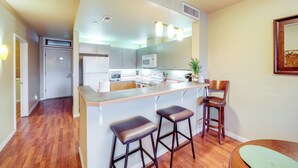 A modern kitchen with a central island, bar stools, and a microwave. - Walk to Lake Chelan: Condo w/ Pool Access (Chelan)