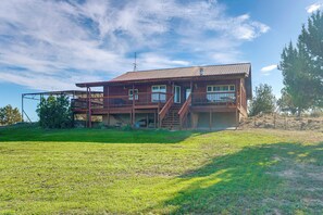 A two-story wooden house with a balcony, a covered porch, and a staircase leading to the upper floor. - Mtn-view Escape w/ Office Space in Cortez! (Cortez)