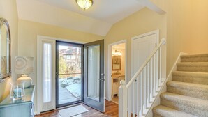 Eine Treppe führt zu einer zweiten Etage, eine Tür zu einem Balkon und ein Badezimmer mit Waschbecken und Spiegel.