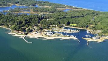 An aerial view of a coastal area with a marina, boats, and residential buildings.