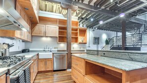 A modern kitchen with wooden cabinets, stainless steel appliances, and a granite countertop. - < 1 Mi to Wittenberg: Eclectic Loft w/ Parking! (Springfield)