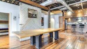 A modern kitchen with wooden flooring, a long wooden bench, and a herringbone-patterned wall. - < 1 Mi to Wittenberg: Eclectic Loft w/ Parking! (Springfield)