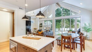 A modern kitchen with a large island, wooden cabinets, and pendant lighting. - Private Hot Tub & Patio: Spacious Cle Elum Home (Cle Elum)
