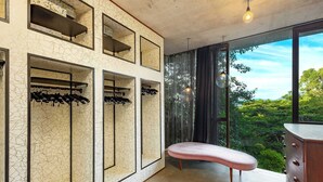 Una habitación moderna con un ventanal grande, una banca y espacio de almacenamiento para zapatos integrado.