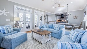 Un salon spacieux avec un canapé bleu clair, une table basse en bois et un tapis à motifs.