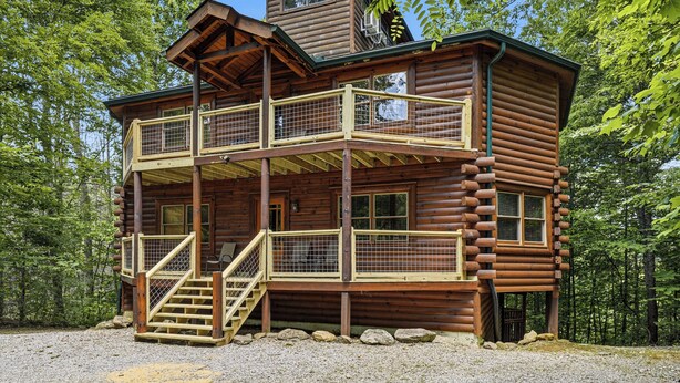 A log cabin with a balcony, a staircase, and a window. - Private Indoor Pool, Hot Tub, Fire Pit, Pool Table, Free Attractions! (Cosby)