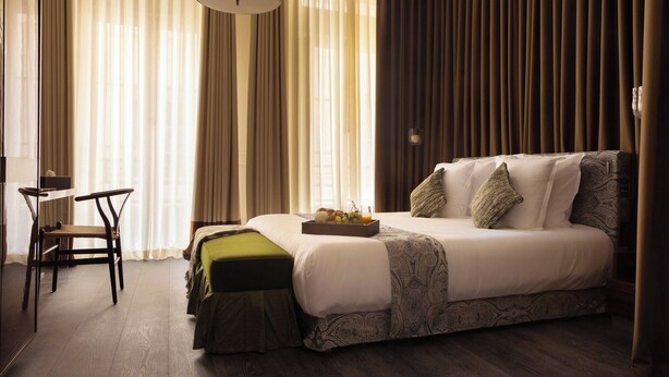 A hotel room with a bed, a desk, and a chair. There is a tray with fruits on the bed. - Palais Bourbon Hotel - Room 12- 2P - Invalides (Paris)