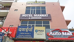 Hotel 'Hotel Mannat' con un cartel que indica habitaciones disponibles.