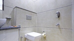 Un baño con inodoro, ducha y lavamanos.