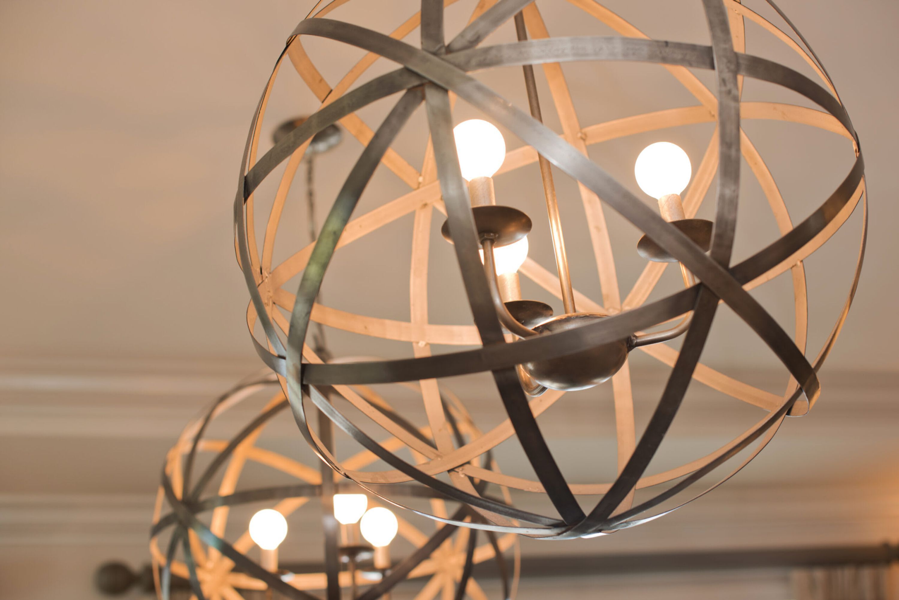 Um lustre metálico esférico com várias lâmpadas.