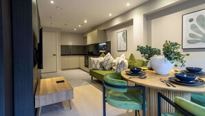 Una cucina moderna con zona pranzo, divano e televisore.