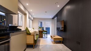 Una cucina moderna con zona pranzo, divano e TV a parete.