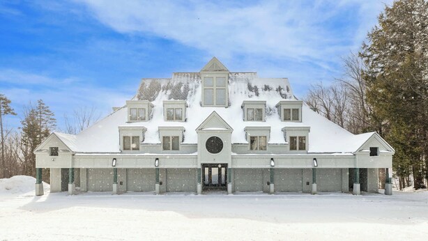 A large, symmetrical building with a central entrance, multiple windows, and a snow-covered roof.