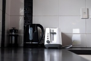A kitchen with a coffee maker, a toaster, and a kettle on a countertop.