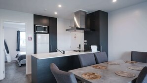 A modern kitchen with a central island, dark cabinetry, and a microwave.