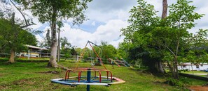 Children can play on the swing set and seesaw in this lush outdoor playground.