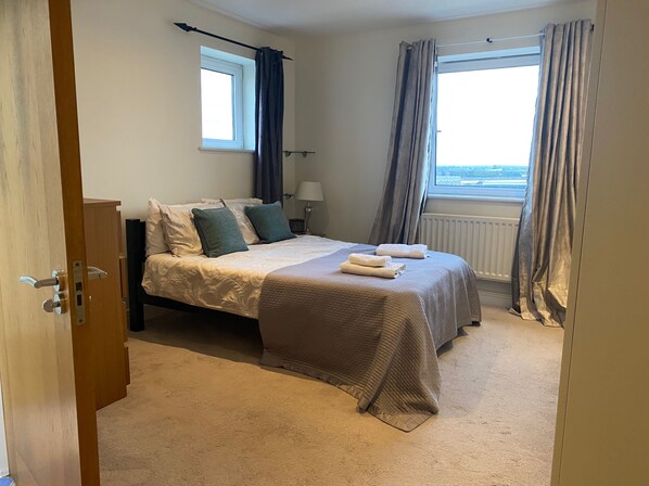 A bedroom with a bed, a window, and a view of the city. - 2 Bed Flat - Sleeps 4 - Parking - Wifi (London)