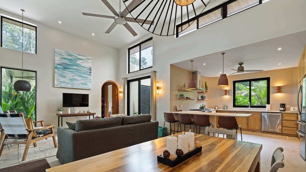 A spacious living area with a dining table, sofa, and kitchen in the background. - Private 4BR Oasis + Pool – Near Playa Grande Beach (Playa Grande)
