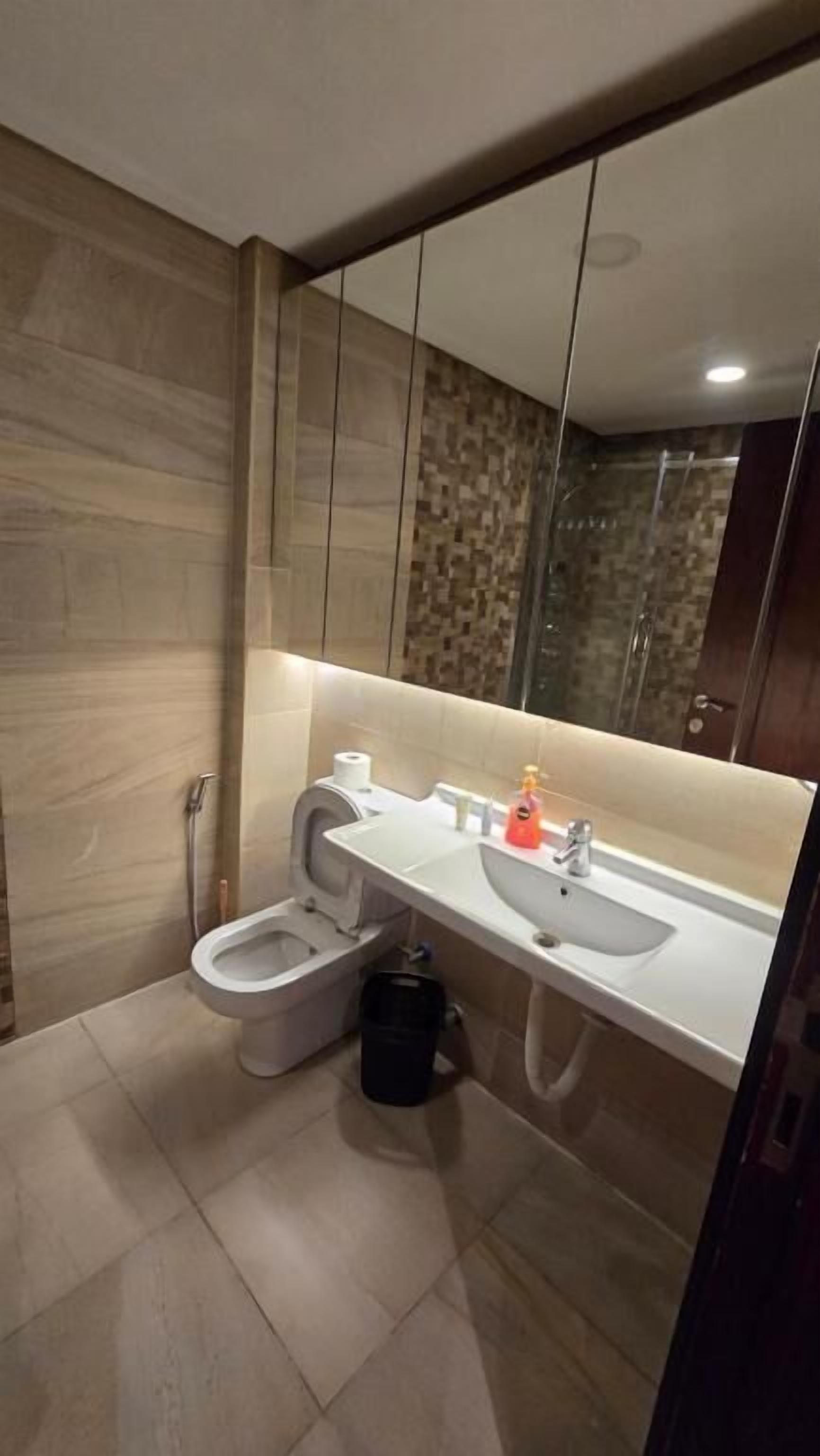 Un baño moderno con inodoro, bidé, lavabo y espejo.