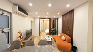 A modern living room with a sofa, TV, and dining area. - Maison 7 New Cairo  (New Cairo)