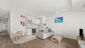 A modern apartment with a kitchen, dining area, and living room.