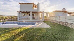 A modern two-story house with a swimming pool, stone walls, and a patio area. - Panor Villas (Rethymno)