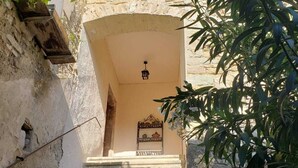 A stone staircase leading to a covered entrance with a lantern above.