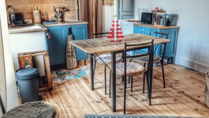A compact kitchen with a wooden table and chairs, a sink, and a microwave.