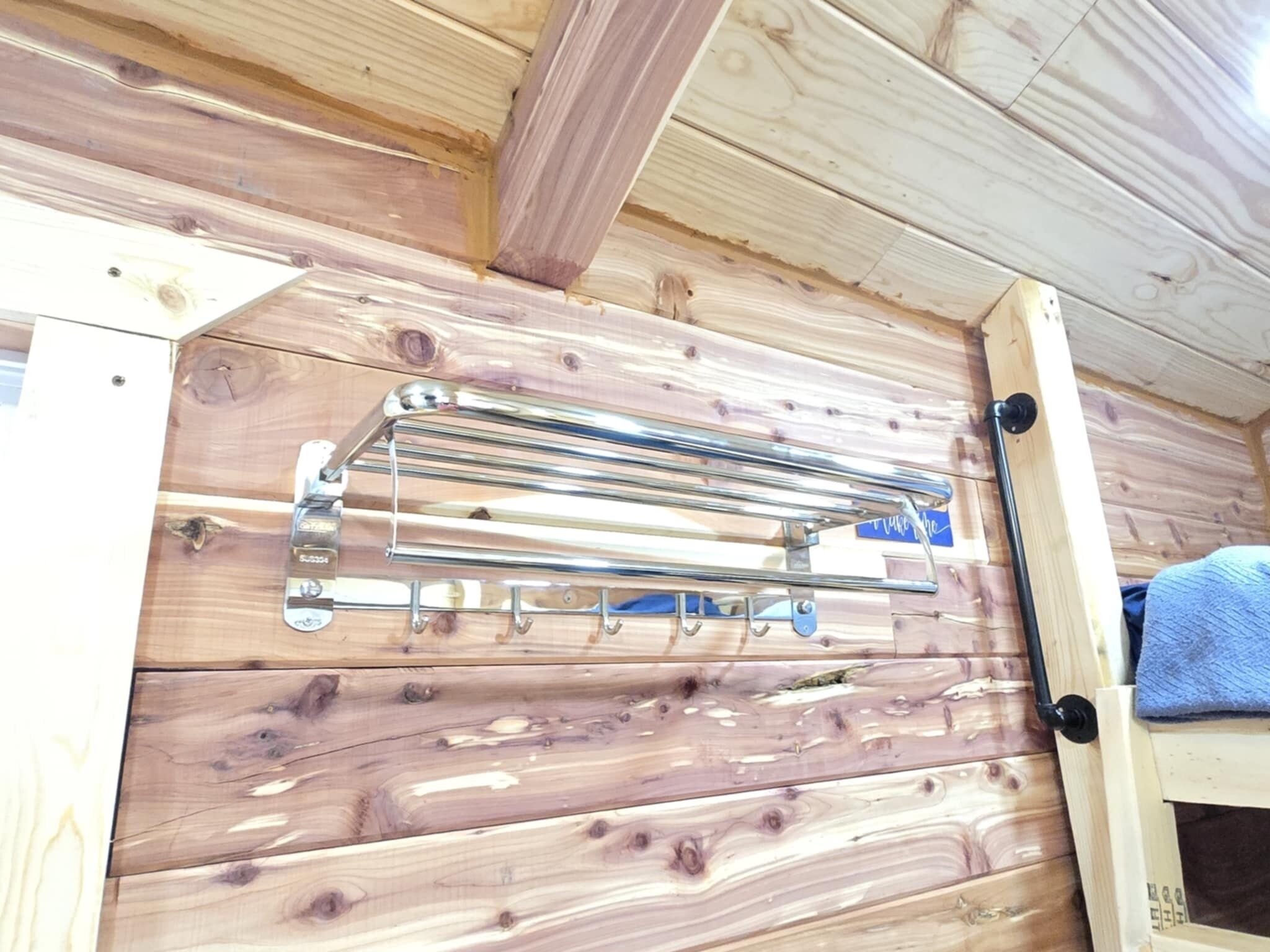 A wooden interior with a metal towel rack mounted on the wall.