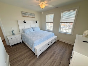 A bedroom with a bed, nightstands, a dresser, a ceiling fan, and windows with blinds. - Southview Condominiums unit 404 Wildwoods Newest Building with a private pool (Wildwood)