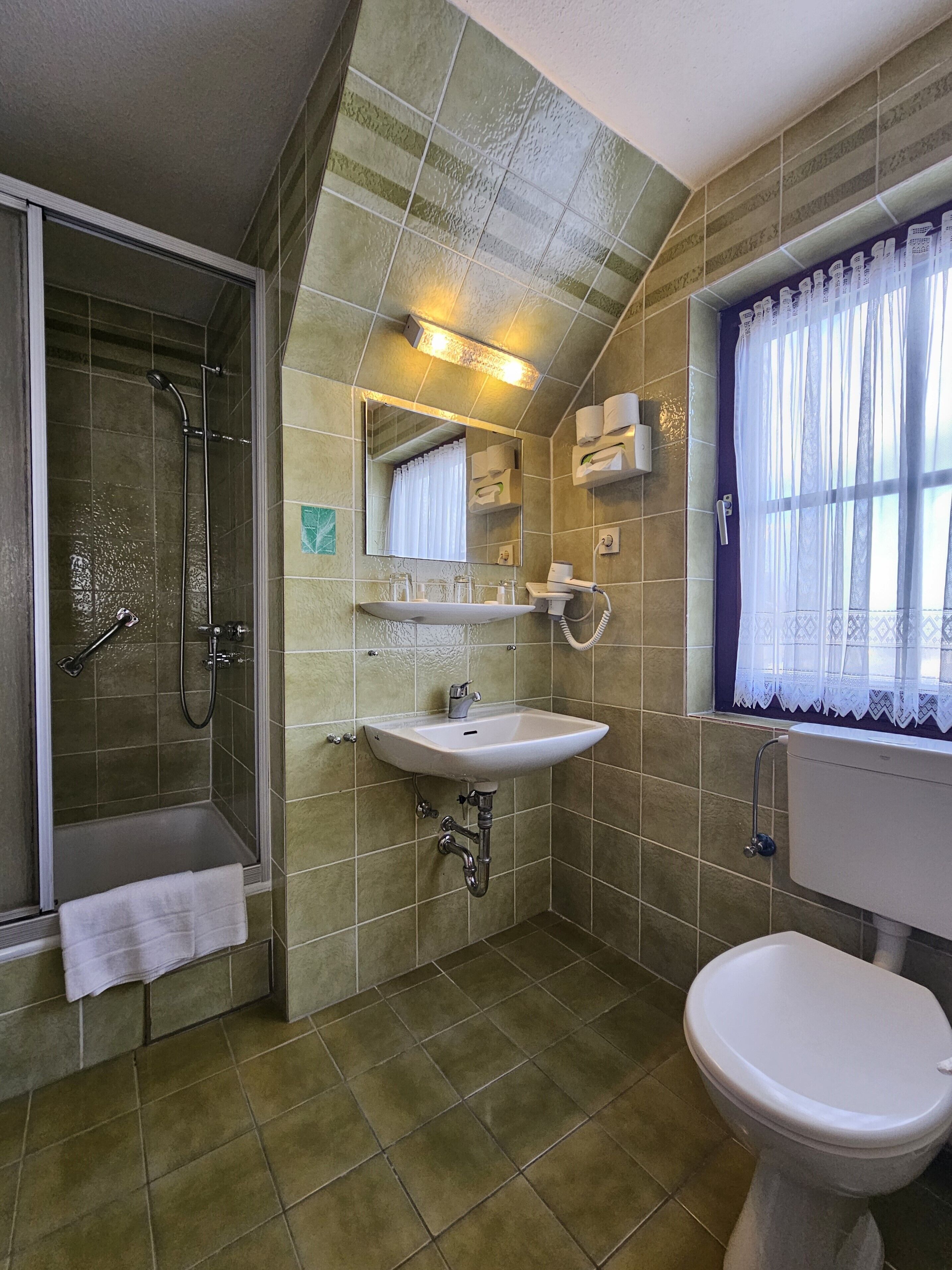 Ein Badezimmer mit Dusche, Waschbecken und Toilette.