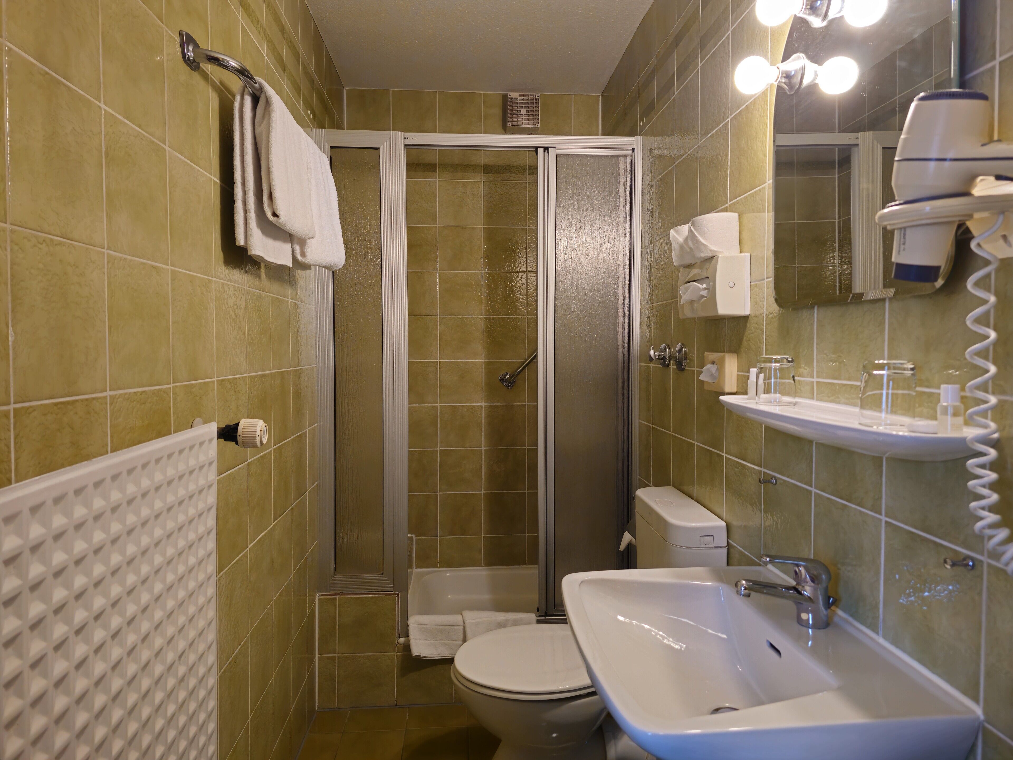 A bathroom with a shower, toilet, and sink.