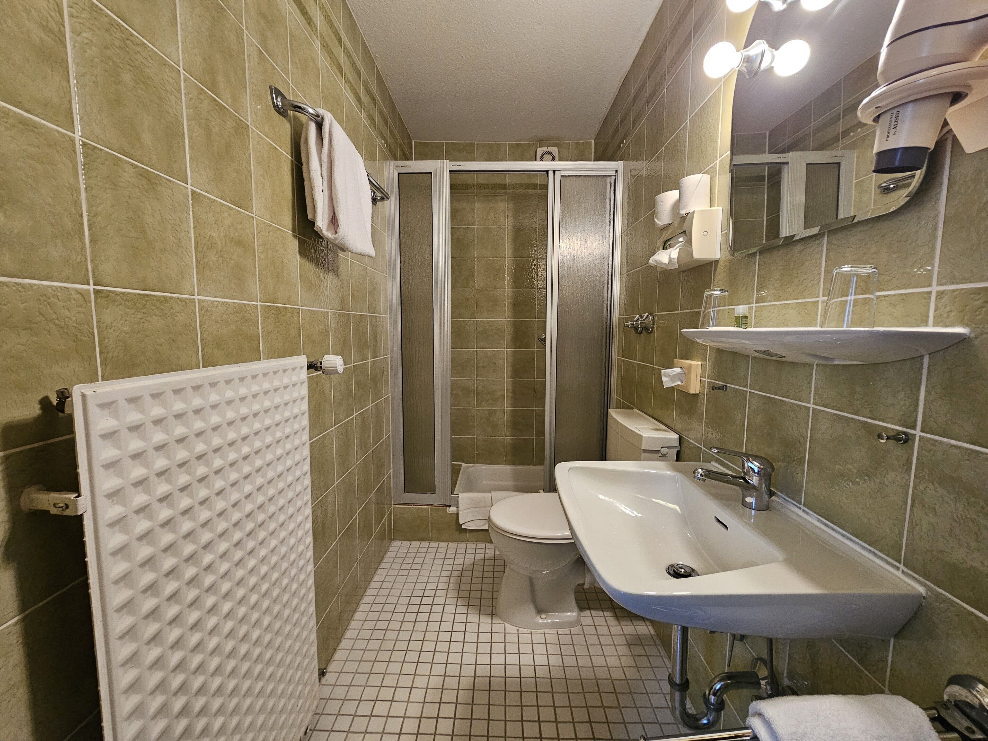 Un baño con ducha, inodoro y lavamanos.