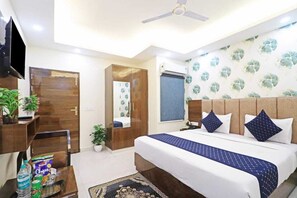 A bedroom with a bed, a wardrobe, a mirror, a television, and a window with a view. - Hotel Vijaydeep Place Near Delhi Airport (New Delhi)