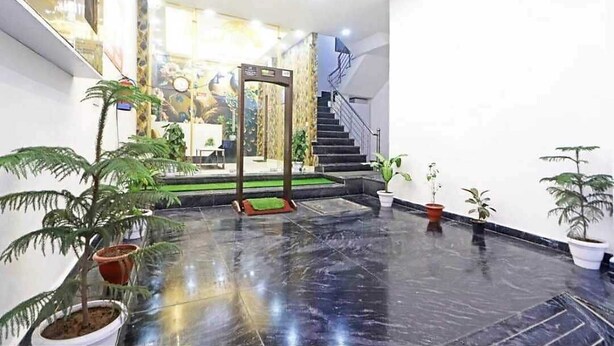 A spacious lobby with a marble floor, a staircase, and several potted plants. - Hotel Vijaydeep Place Near Delhi Airport (New Delhi)