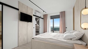 A modern bedroom with a bed, a TV mounted on the wall, and a large window with curtains. - Villa Freedom (Vodice)