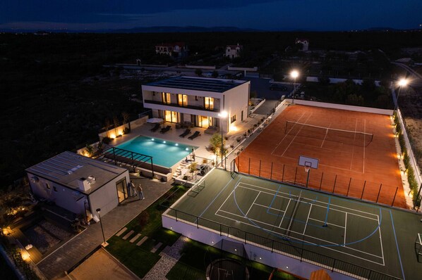 A modern building with a swimming pool and a tennis court. - Villa Freedom (Vodice)
