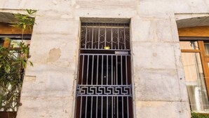 Fachada de prédio com uma janela e barras de metal decorativas, exibindo o número 