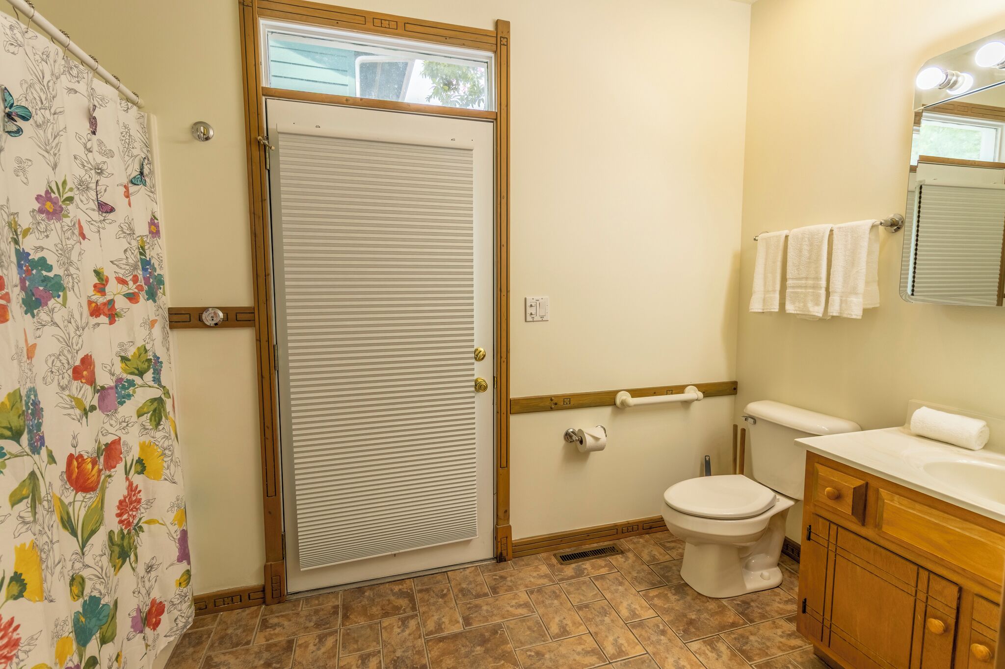 A bathroom with a toilet, sink, and shower curtain.