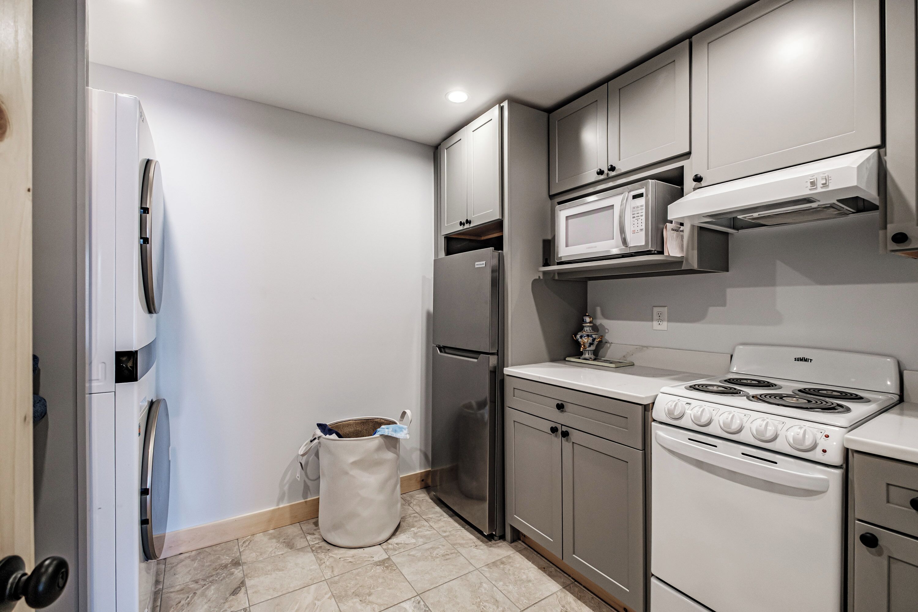 Una cocina compacta equipada con refrigerador, microondas y estufa.