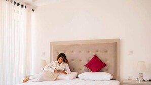 A hotel room with a large bed, a bedside table with a lamp, and a chair.