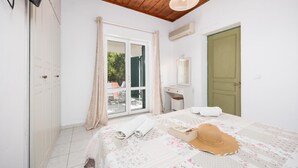 Un dormitorio con cama, cómoda, espejo y ventana con cortinas.