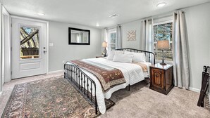 A bedroom with a bed, bedside table, lamp, and a window with curtains. - University Place, family stay, practically on campus (Siloam Springs)