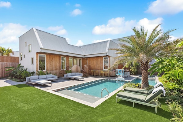 A modern house with a swimming pool, outdoor furniture, and a well-maintained lawn. - The Herald at CastleDay - Private Pool, Spa (New Orleans)