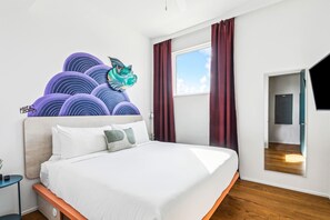 A modern hotel room with a large bed, a decorative wall art piece, a window with curtains, and a view of the sky. - The Herald at CastleDay - Private Pool, Spa (New Orleans)